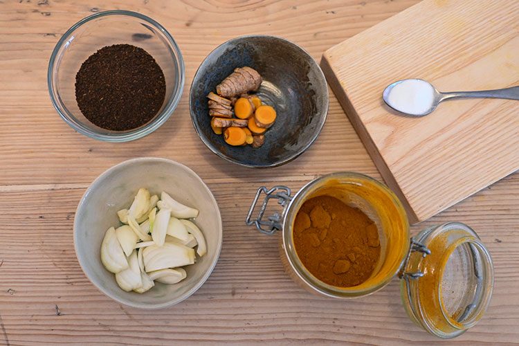 Zwiebeln, Currypulver, Kurkuma und Kakao sind in Schälchen für das Herstellen von Naturfarben vorbereitet.